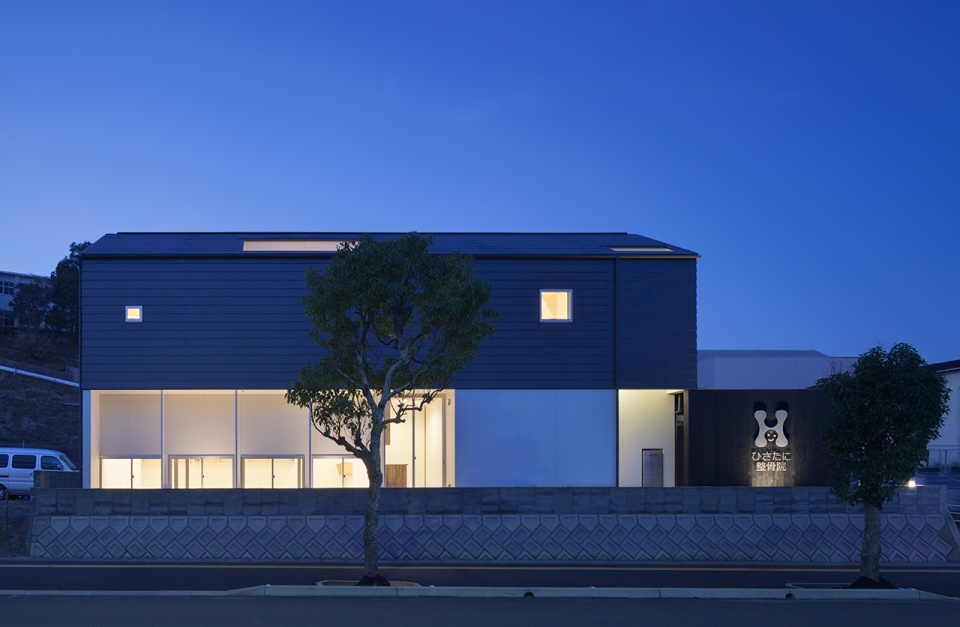 道路側から見た夜の外観、屋根には２階デッキテラスの穴が開いている