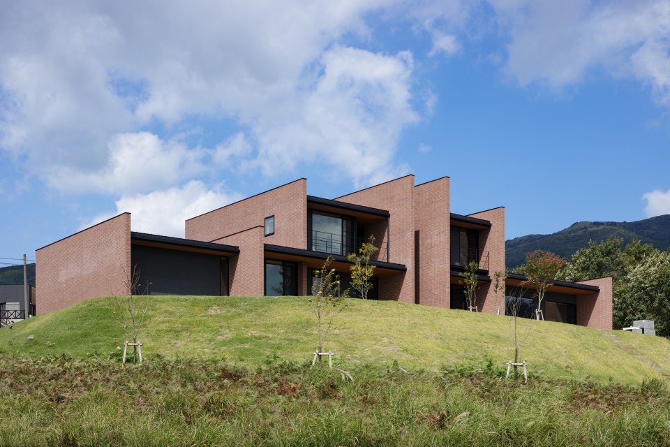 周辺の山々と呼応するように重なる外壁