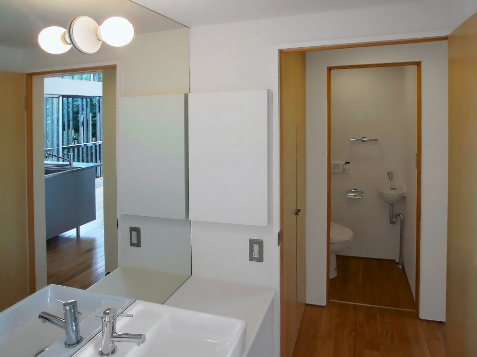 洗面脱衣室から便所を望む
洗面台の鏡は、壁面鏡とし視覚的広がりを持たせています。